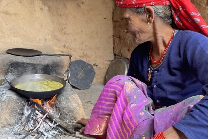 a village woman cooking a local dish with a traditional method